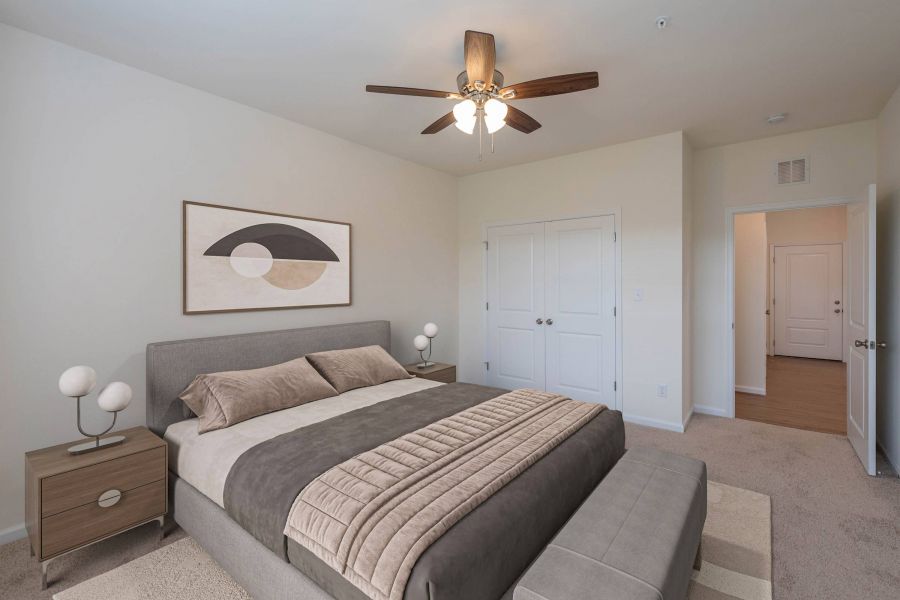 Modern bedroom with a gray bed, two nightstands, abstract art, and a ceiling fan with lights.