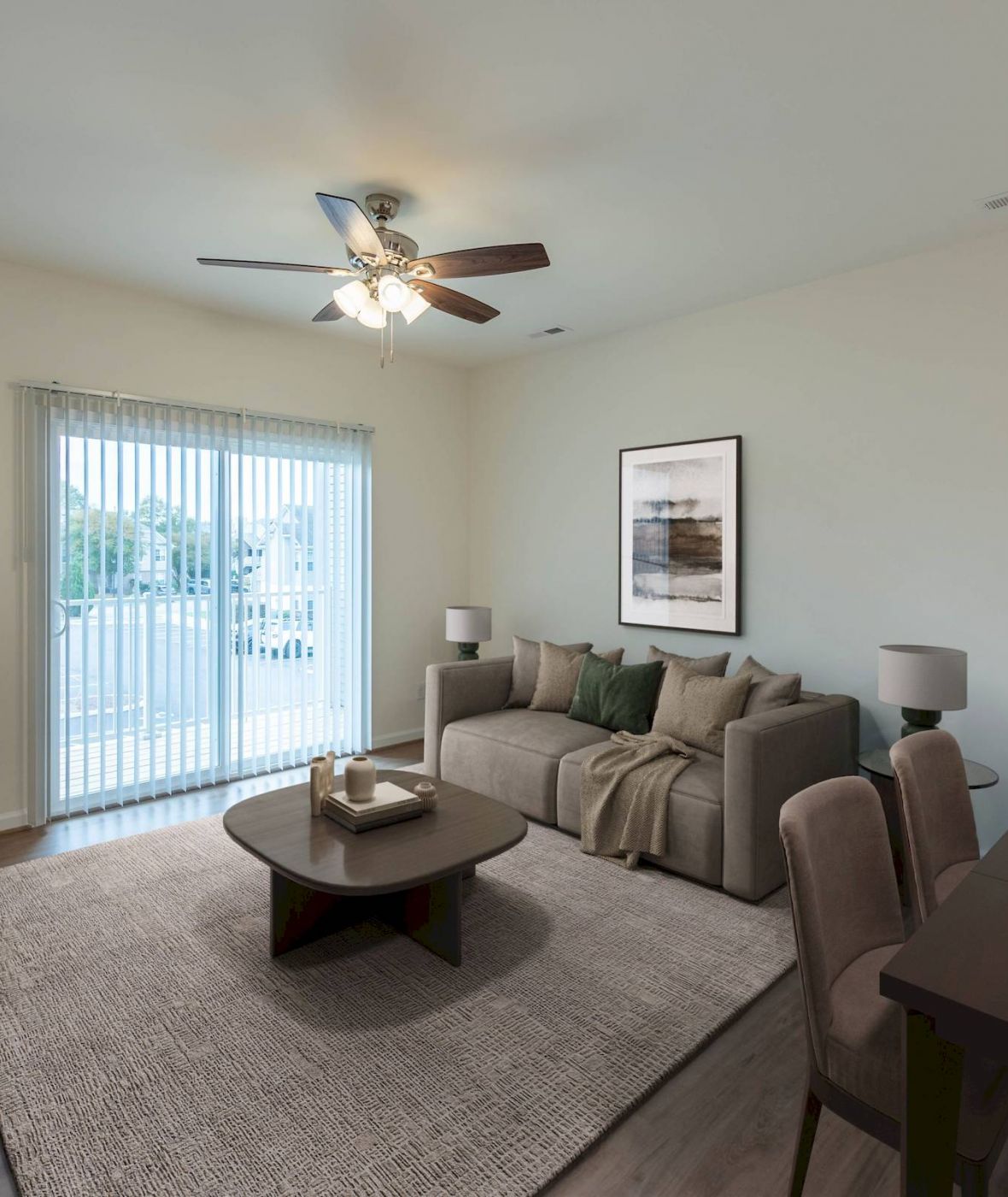 Modern living room with a sofa, coffee table, TV, dining table, and sliding glass doors letting in natural light.